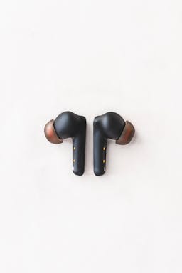 Black earbuds with wooden caps against a white backdrop