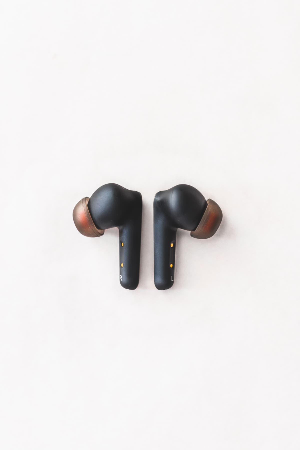 Black wireless earphones with brown silicon caps